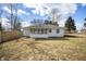 Back exterior view shows sunroom addition and level yard with wooden privacy fence to the left at 3626 St. Charles St, Anderson, IN 46013