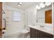 Bathroom with white tiles, gray vanity with a white countertop and undermount sink and a shower with tub at 3626 St. Charles St, Anderson, IN 46013