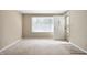 Bright, carpeted living room with large window and neutral walls at 3626 St. Charles St, Anderson, IN 46013