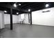 Spacious basement with painted brick walls, dark ceiling beams, and concrete floor at 3645 N Delaware St, Indianapolis, IN 46205