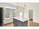Bright kitchen with gray cabinets, stainless steel refrigerator, white countertops, and a kitchen island at 3917 Wren Dr, Brownsburg, IN 46112
