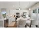 A bright kitchen featuring white cabinets, stainless steel appliances, a kitchen island with chairs, and modern lighting at 3917 Wren Dr, Brownsburg, IN 46112