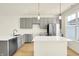 Modern kitchen featuring gray cabinets, stainless steel appliances, a kitchen island with white countertops, and light wood flooring at 3917 Wren Dr, Brownsburg, IN 46112