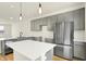 Modern kitchen featuring gray cabinets, stainless steel appliances, a kitchen island with white countertops, and light wood flooring at 3917 Wren Dr, Brownsburg, IN 46112
