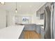 Modern kitchen featuring gray cabinets, stainless steel appliances, a kitchen island with white countertops, and light wood flooring at 3917 Wren Dr, Brownsburg, IN 46112