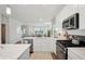 Open kitchen featuring white cabinets, stainless steel appliances, and a view into the living room at 3917 Wren Dr, Brownsburg, IN 46112