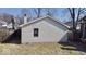 Backyard view of the house with vinyl siding, a sidewalk and green grass at 4619 Carrollton Ave, Indianapolis, IN 46205