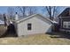 Backyard view of the house with vinyl siding, a sidewalk and green grass at 4619 Carrollton Ave, Indianapolis, IN 46205