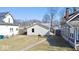 Backyard view of the house with vinyl siding, a sidewalk and green grass at 4619 Carrollton Ave, Indianapolis, IN 46205