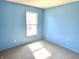Bedroom with blue painted walls, carpet flooring, and a window letting in plenty of natural light at 4619 Carrollton Ave, Indianapolis, IN 46205