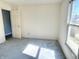 Bedroom with white walls, carpet flooring, a window letting in natural light, and a white door at 4619 Carrollton Ave, Indianapolis, IN 46205