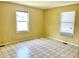 Sunny bedroom featuring linoleum tile flooring and two windows to let in natural light at 4619 Carrollton Ave, Indianapolis, IN 46205