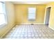 Bedroom with tan colored walls, linoleum tile flooring and a window with horizontal blinds at 4619 Carrollton Ave, Indianapolis, IN 46205
