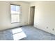 Bedroom with white walls, carpet flooring, a window letting in natural light, and a white door at 4619 Carrollton Ave, Indianapolis, IN 46205