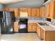 Functional kitchen with wood cabinets, black appliances, and laminate countertops ready for culinary adventures and customization at 4619 Carrollton Ave, Indianapolis, IN 46205