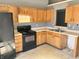 Bright kitchen featuring wooden cabinets, black appliances, and linoleum tile flooring at 4619 Carrollton Ave, Indianapolis, IN 46205