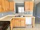 Spacious kitchen with wood cabinets, dual basin sink, and a view into the adjoining room at 4619 Carrollton Ave, Indianapolis, IN 46205