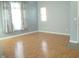 A cozy living room featuring shiny hardwood floors, windows, and neutral paint at 515 Bridgestone Dr, Mooresville, IN 46158