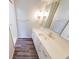 Bathroom vanity with a unique sink, bright lighting, and decorative mirrors and wood floors at 5525 Roxbury Ter, Indianapolis, IN 46226