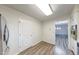 Hallway featuring a door to another room, wood-look flooring, and a bright ceiling light at 5525 Roxbury Ter, Indianapolis, IN 46226