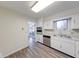 Well-lit kitchen with modern appliances, white cabinets, and wood-look flooring at 5525 Roxbury Ter, Indianapolis, IN 46226