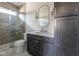 Modern bathroom featuring a glass shower, gray vanity with marble countertop, and an oval mirror at 5537 Broadway St, Indianapolis, IN 46220