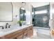 Stylish bathroom with dual vanities, a soaking tub, and elegant fixtures and blue tile at 5537 Broadway St, Indianapolis, IN 46220