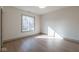 Bright, empty bedroom featuring hardwood floors, and natural light from the window at 5537 Broadway St, Indianapolis, IN 46220