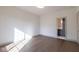 Sun-filled empty bedroom with hardwood floors and ensuite bathroom entrance at 5537 Broadway St, Indianapolis, IN 46220
