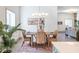 Dining area with modern lighting, a textured rug, and rattan chairs located next to a living area at 5537 Broadway St, Indianapolis, IN 46220
