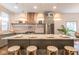 Bright kitchen with light-green cabinets, marble countertops, stainless appliances, and a large island at 5537 Broadway St, Indianapolis, IN 46220
