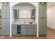 Butler's pantry with marble countertops, wine fridge, cabinets, and wet bar under an arched entry at 5537 Broadway St, Indianapolis, IN 46220