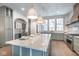 Bright kitchen featuring large island, marble countertops, stainless steel appliances, and designer pendant lighting at 5537 Broadway St, Indianapolis, IN 46220