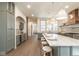 Open kitchen with large island, marble countertops, stainless appliances, and custom cabinetry with rattan counter stools at 5537 Broadway St, Indianapolis, IN 46220
