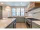Kitchen features marble backsplash, countertops, large island, custom range hood and stainless steel appliances at 5537 Broadway St, Indianapolis, IN 46220