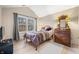 Cozy bedroom featuring a bed, wood floors, vaulted ceiling, and natural light from a large window at 5721 Quail Crossing Dr, Indianapolis, IN 46237