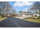 Beautiful home with a three-car garage and driveway surrounded by trees under a sunny sky at 5721 Quail Crossing Dr, Indianapolis, IN 46237