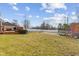 Spacious backyard with a wooden deck, trampoline, grassy area, and a white fence at 5732 Bold Ruler Dr, Indianapolis, IN 46237
