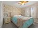 Comfortable bedroom with floral wallpaper, a plush bed, bedside tables, and natural light at 5732 Bold Ruler Dr, Indianapolis, IN 46237