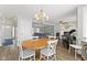 Open-concept dining area with a wooden table and a view of the living room with fireplace at 5732 Bold Ruler Dr, Indianapolis, IN 46237