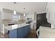 Bright kitchen featuring white cabinets, a blue island, and stylish backsplash at 5732 Bold Ruler Dr, Indianapolis, IN 46237