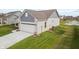 A view of the home's garage, a pond, and green space at 602 Tuscany Trl, Lapel, IN 46051