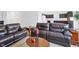 Living room featuring comfortable dark leather furniture, accent tables, and light wood floors at 602 Tuscany Trl, Lapel, IN 46051