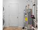 Utility room with water heater, washing machine, dryer and a door leading to another space at 602 Tuscany Trl, Lapel, IN 46051