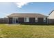 A well-maintained backyard features a brick home with a sliding door and a concrete patio at 6400 Woodland Ln, McCordsville, IN 46055