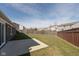 A large backyard with a green lawn, a wooden fence, and a concrete patio offers space for relaxation and outdoor activities at 6400 Woodland Ln, McCordsville, IN 46055
