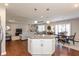 Open concept kitchen and living area featuring white cabinets, granite counters and stainless steel appliances at 6400 Woodland Ln, McCordsville, IN 46055
