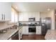 Modern kitchen with white cabinets, stainless steel appliances, granite counters, and hardwood floors at 6400 Woodland Ln, McCordsville, IN 46055