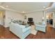 Bright living room with tray ceiling, recessed lighting, hardwood floors, and plush sofas at 6400 Woodland Ln, McCordsville, IN 46055