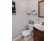 Clean bathroom with wood vanity, a modern sink, a toilet and decorative shelf with charming signage at 6616 W 15Th St, Indianapolis, IN 46214